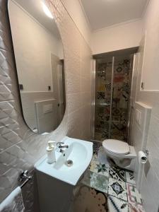 ein Badezimmer mit einem Waschbecken, einem WC und einem Spiegel in der Unterkunft Apartment Get in Supetar