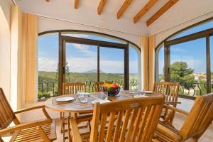 a dining room with a table and chairs and windows at Pinecrest in Jávea