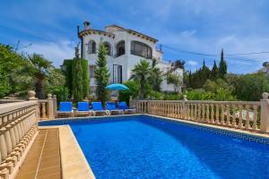 a villa with a swimming pool in front of a house at Pinecrest in Jávea