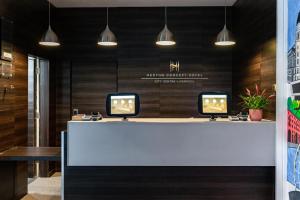 a reception desk with two monitors on top of it at Heeton Concept Hotel - City Centre Liverpool in Liverpool