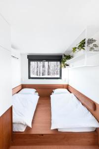 two beds in a small room with a window at Good Spot Morze in Rowy