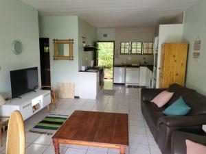 a living room with a couch and a table at Eden Wilds 30 in Port Edward