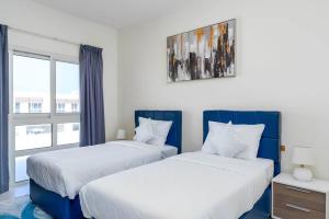 dwa łóżka w pokoju z oknem w obiekcie NEW! Luxurious 3Bedroom Villa with Balcony in RAK w mieście Ras al-Chajma