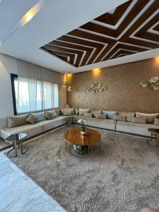 ein Wohnzimmer mit einem Sofa und einem Tisch in der Unterkunft VILLA GOLF ARGAN in Marrakesch