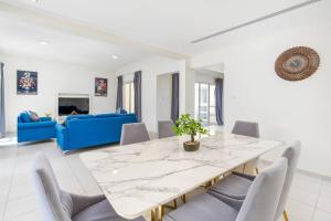 jadalnia ze stołem i niebieską kanapą w obiekcie NEW! Luxurious 3Bedroom Villa with Balcony in RAK w mieście Ras al-Chajma