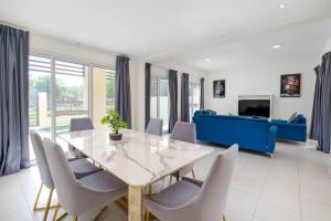 jadalnia ze stołem i krzesłami oraz niebieską kanapą w obiekcie NEW! Luxurious 3Bedroom Villa with Balcony in RAK w mieście Ras al-Chajma