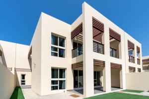 widok na biały budynek z dużymi oknami w obiekcie NEW! Luxurious 3Bedroom Villa with Balcony in RAK w mieście Ras al-Chajma