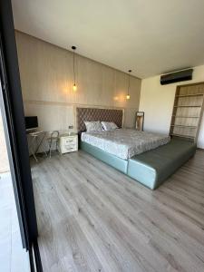 Schlafzimmer mit einem Bett, einem Schreibtisch und einem TV in der Unterkunft VILLA GOLF ARGAN in Marrakesch