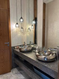 zwei Waschbecken im Bad mit zwei Spiegeln in der Unterkunft VILLA GOLF ARGAN in Marrakesch