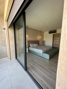 Schlafzimmer mit einem Bett und einer Glasschiebetür in der Unterkunft VILLA GOLF ARGAN in Marrakesch