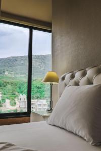 a bedroom with a bed and a large window at Rapos Resort Hotel in Himare