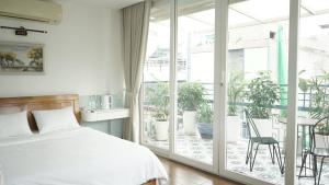 a bedroom with a bed and a balcony with plants at MAIAM Homestay in Ho Chi Minh City