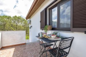a patio with a table and chairs and a window at Casa Vacanza Baratz 3 in Alghero