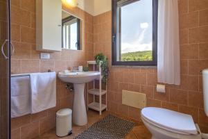 La salle de bains est pourvue d'un lavabo, de toilettes et d'une fenêtre. dans l'établissement Casa Vacanza Baratz 3, à Alghero