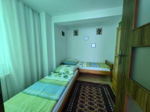 2 łóżka pojedyncze w niewielkim pokoju z oknem w obiekcie Vanessa-Apart w Grzybowie