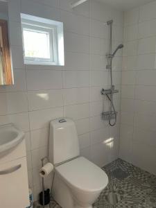 a white bathroom with a toilet and a window at Fiskarstugan i Norra Häljaröd in Norra Häljaröd