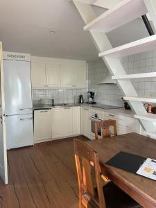 una cucina con un tavolo e un frigorifero bianco di Fiskarstugan i Norra Häljaröd a Norra Häljaröd