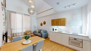 a kitchen and a living room with a table and chairs at Apartamentos La Casa El Palo in El Rompido