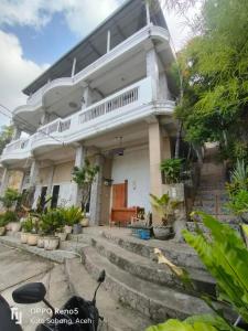 IboihにあるFURQAN GUEST HOUSE Familyの玄関と階段が前にある家