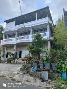 IboihにあるFURQAN GUEST HOUSE Familyのバルコニー付きの広い白い家 +3枚の写真