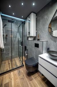 a bathroom with a shower and a toilet and a sink at Apartment Deluxe Vision in Varna City