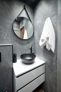 a bathroom with a sink and a mirror at Apartment Deluxe Vision in Varna City