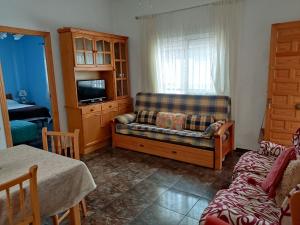 sala de estar con sofá y TV en Playa Rihuete 2 en Puerto de Mazarrón