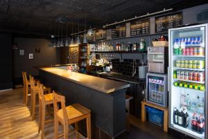 un bar con sillas y una nevera con bebidas en Patio Hostel, en Bratislava