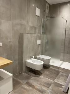 La salle de bains est pourvue de toilettes, d'un lavabo et d'une douche. dans l'établissement Studio Apartment Old Town Riva, à Riva del Garda