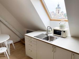 a small kitchen with a sink and a window at Boutique apartments in Bansk&aacute; &Scaron;tiavnica
