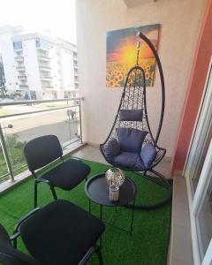 een kamer met stoelen en een schommel op een balkon bij Apartman Dionis Centar in Trebinje