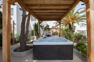 an outdoor hot tub under a wooden pergola at Levantes House Mykonos in Ano Mera