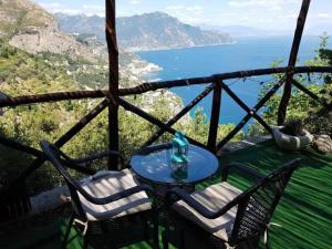 una mesa y sillas con vistas al océano en La Casetta Nel Bosco, Amalfi, en Amalfi