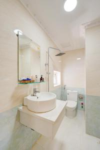 a white bathroom with a sink and a toilet at The Moment - Quang Anh Hotel Vũng tàu in Vung Tau +42 photos