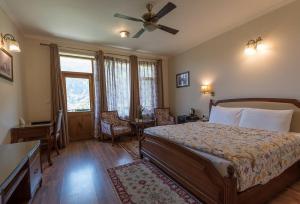 a bedroom with a bed and a table and chairs at The Anantmaya Resort in Manāli