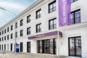 a white building with a purple sign on it at Premier Inn Regensburg City Centre in Regensburg