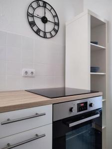 - une horloge sur le mur au-dessus d'une cuisinière dans la cuisine dans l'établissement 'BRIGHT 29' schöne, ruhige Innenstadtlage in Bielefeld, 400 m bis Klinikum Mitte, Smart TV, WLAN, à Bielefeld