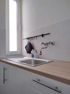 eine Küchentheke mit einem Waschbecken und einem Spiegel in der Unterkunft 'BRIGHT 29' schöne, ruhige Innenstadtlage in Bielefeld, 400 m bis Klinikum Mitte, Smart TV, WLAN in Bielefeld