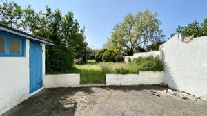 une maison avec une porte bleue et une cour dans l'établissement La Graveline, au Crotoy