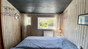 une chambre avec un lit bleu avec une fenêtre dans l'établissement La Graveline, au Crotoy