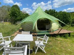 a tent with chairs and a table and a picnic table at Loire Valley Llama Farm Stay in Lavernat