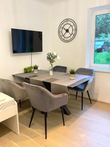 a dining room with a table and chairs and a clock at Ein Traum im Leechwald nähe LKH in Graz