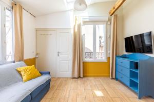 salon z niebieską kanapą i telewizorem w obiekcie Lovely apartment Paris Saint-Lazare Opéra w Paryżu
