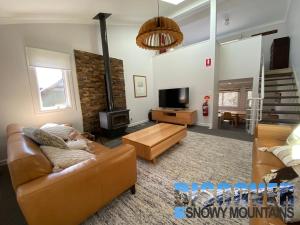 a living room with a couch and a fireplace at Three Bears 3 in Thredbo