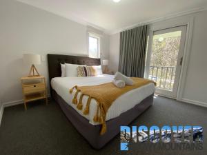 Un dormitorio con una cama grande y una ventana en Three Bears 3 en Thredbo