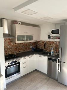 a kitchen with white cabinets and stainless steel appliances at House Lovre in Zadar