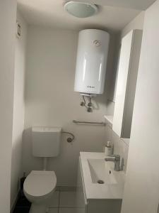 a bathroom with a white toilet and a sink at House Lovre in Zadar
