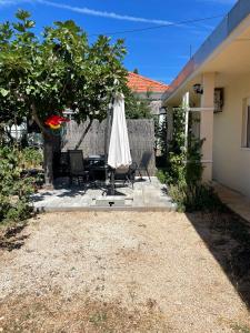 a patio with an umbrella and a table and chairs at House Lovre in Zadar