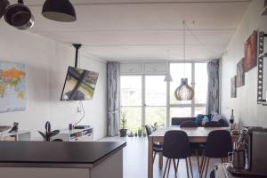 a kitchen and living room with a table and chairs at Nordic design flat including bikes in Copenhagen
