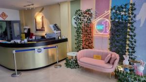 poczekalnia z różowym krzesłem w sklepie w obiekcie One Point Hotel @ King Centre w mieście Kuching